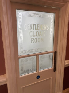 Acid etched 'Gentlemens Toilet' glass door with Greek key border, Royal Hall, Harrogate