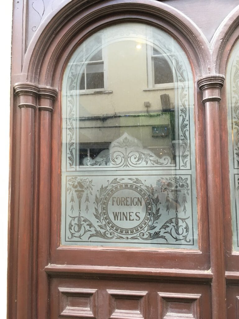 Arched timber door with etched panel and oval lettering