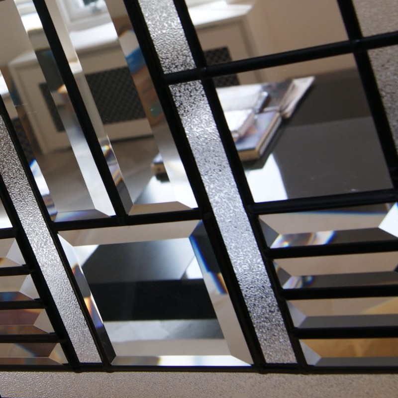 Close-up of bevelled glass panes and textured glass held in black lead lines