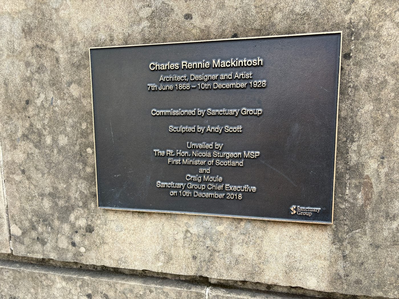 Plaque beside the Mackintosh statue naming the sculptor Andy Scott