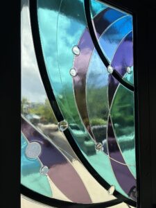 Close-up of fanlight glass in blue, green and purple segments with clear glass jewels