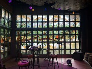 Gridded tree window with a stage and chairs in front