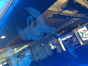Deep carved bird panel lit in blue seen at an angle