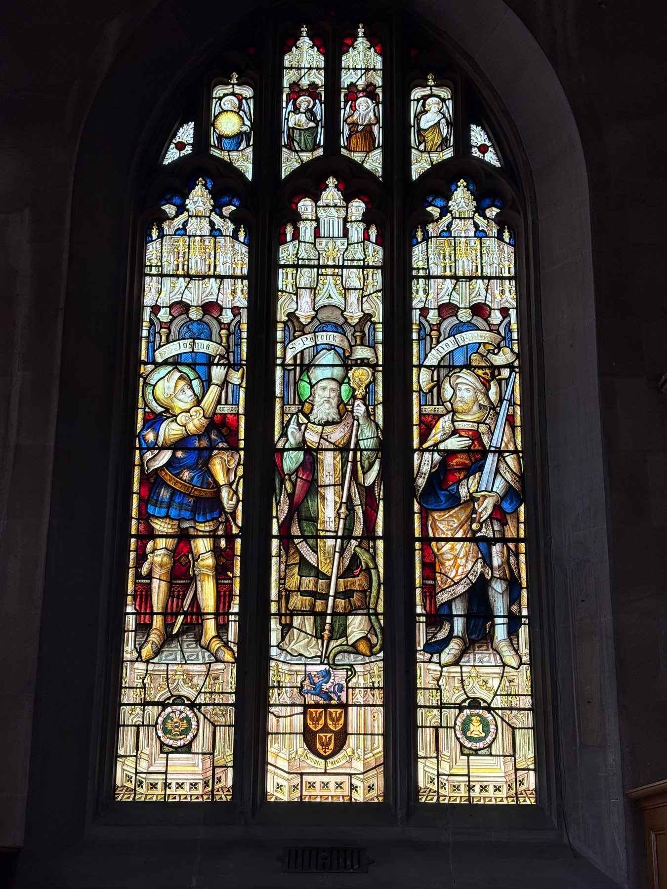 Three-light church window with robed figures under canopies