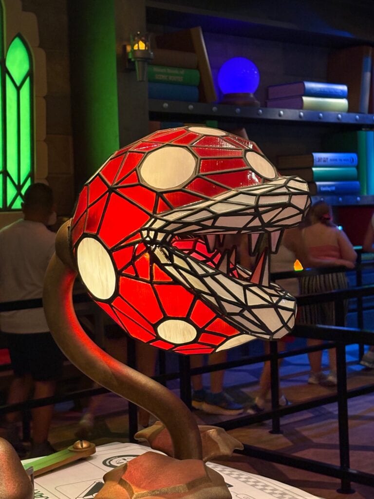 Red and white stained glass lamp shade shaped like a snapping carnivorous plant with teeth