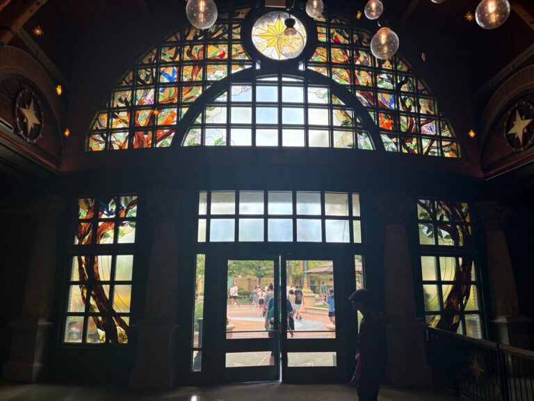 Entrance hall with a domed multicoloured window and flanking windows with tree and foliage designs
