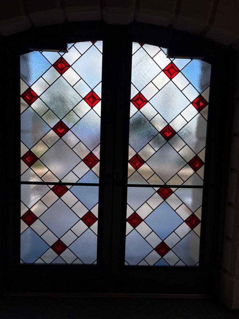 Pair of arched door windows in clear leaded diamond quarries with red faceted jewels
