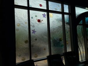 Windows of frosted textured glass with sea-life relief, stars, bubbles and coloured glass jewels