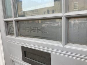 Etched glass pane in a white glazed door