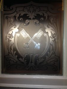 Etched glass panel with crossed keys close view
