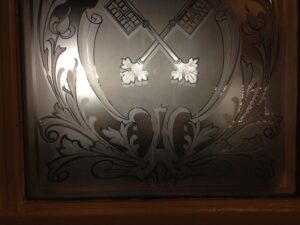Etched glass panel with crossed keys in timber frame
