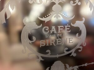 Etched glass screen scrollwork and lettering close up