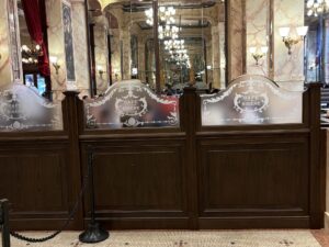 Etched glass screens in a row along wooden panelling