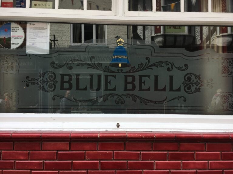 Etched window with lettered banner and scroll border
