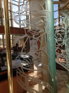 Freestanding glass screen with carved face close view