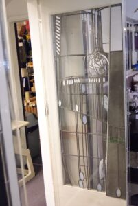 Glazed door with rose panel in white frame open