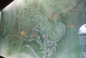 Green glass wall carved dragon head close up