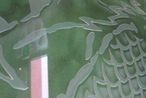 Green glass wall carved dragon scales close up