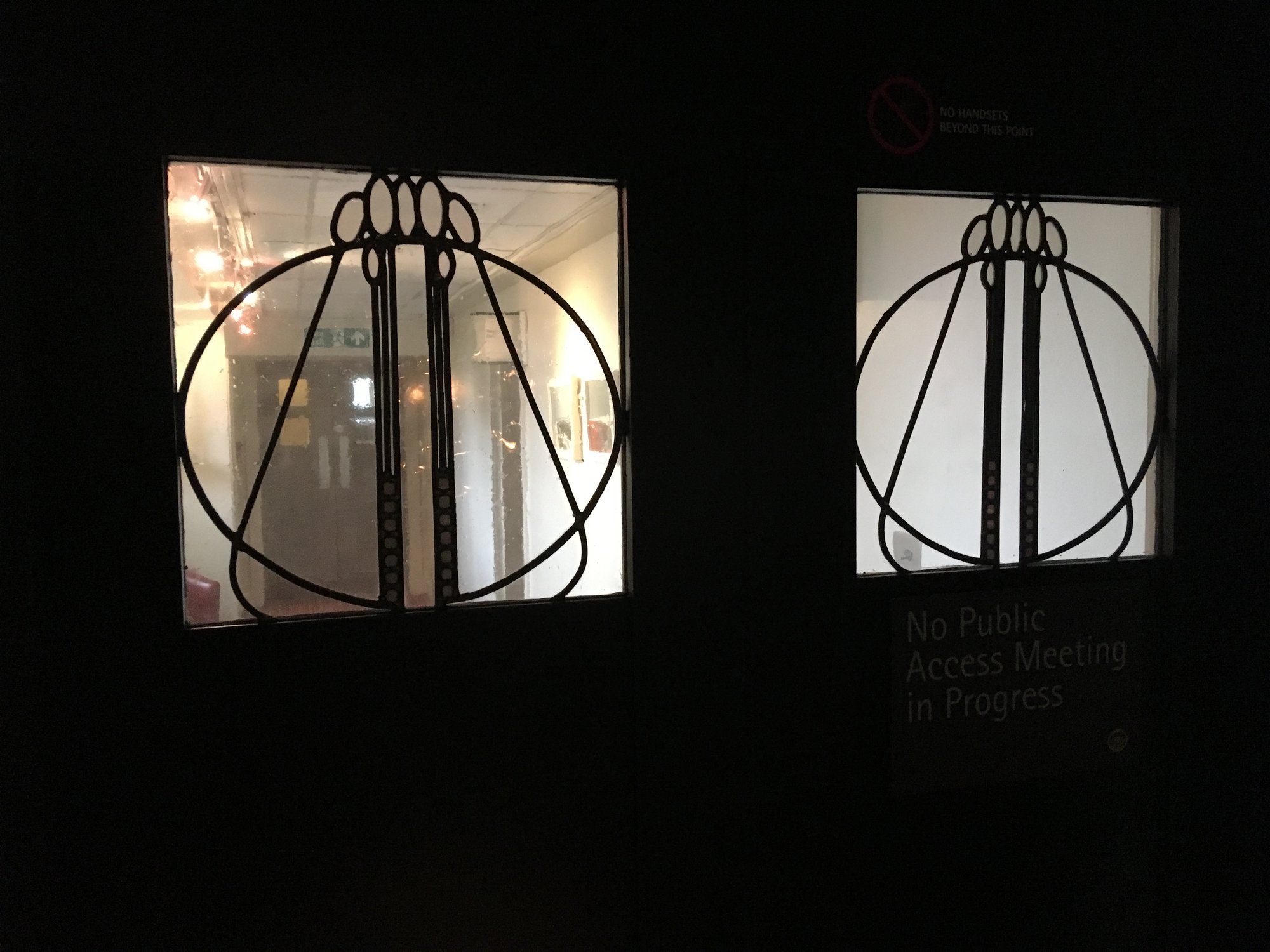 Black doors with two leaded glass panels, each with a circle and long vertical lines