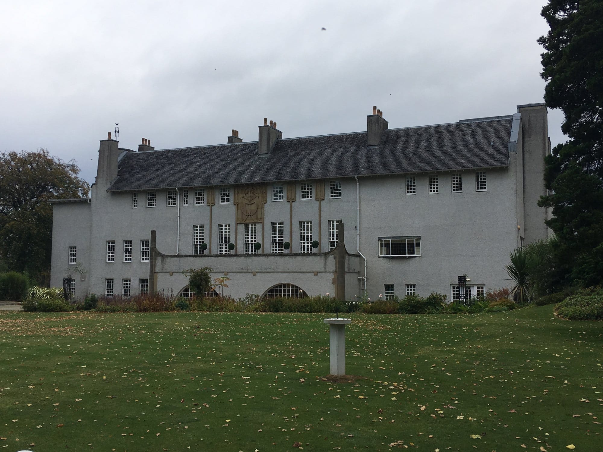 The garden front of House for an Art Lover across the lawn, under a grey sky