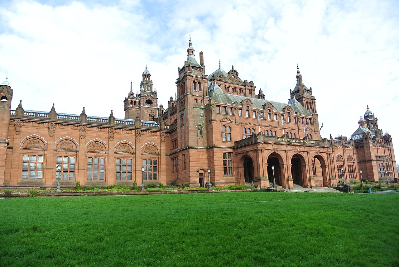 Kelvingrove Art Gallery and Museum in Glasgow, a red sandstone building with towers, seen across the lawn