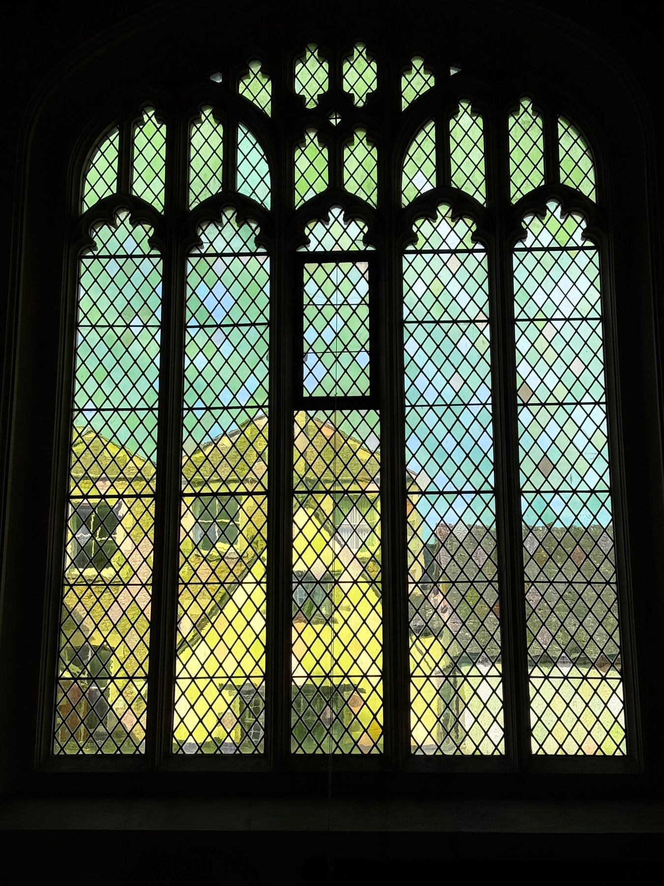 Church window of clear leaded diamond quarries with a mullion and tracery above