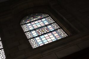 Close view of pale pink, blue and cream leaded quarries in an arched window