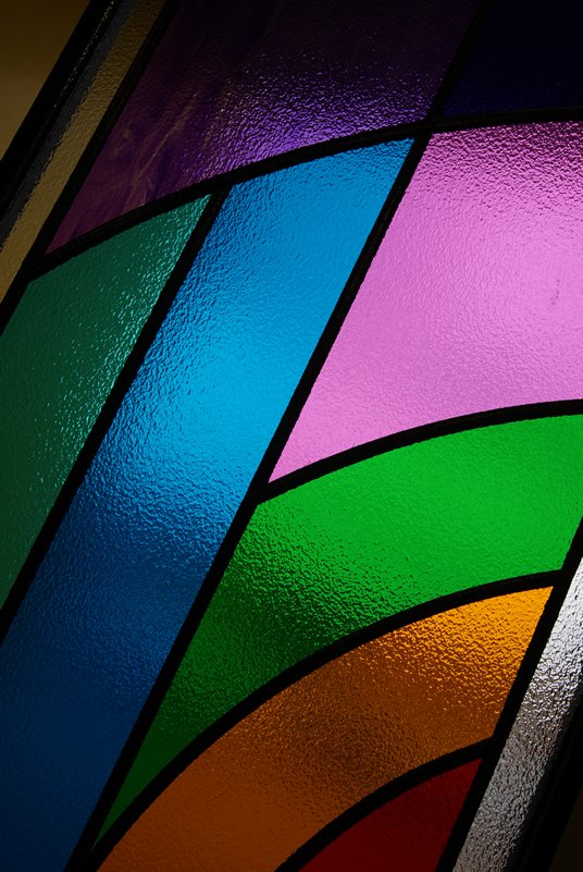 Close view of bright bands of colour in overlay stained glass
