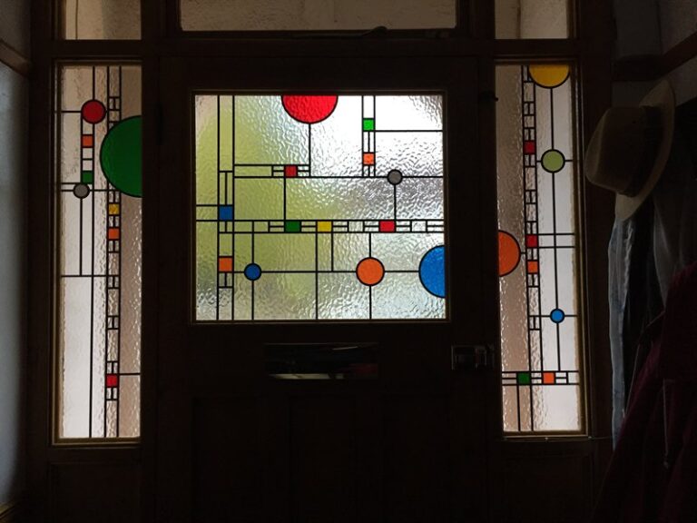 Front door and side windows in a prairie style design in overlay stained glass