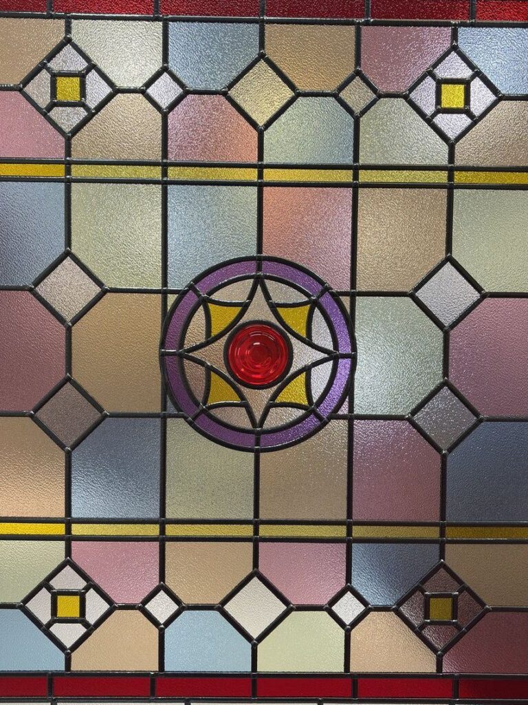 Victorian style overlay stained glass panel with a red border and a central roundel
