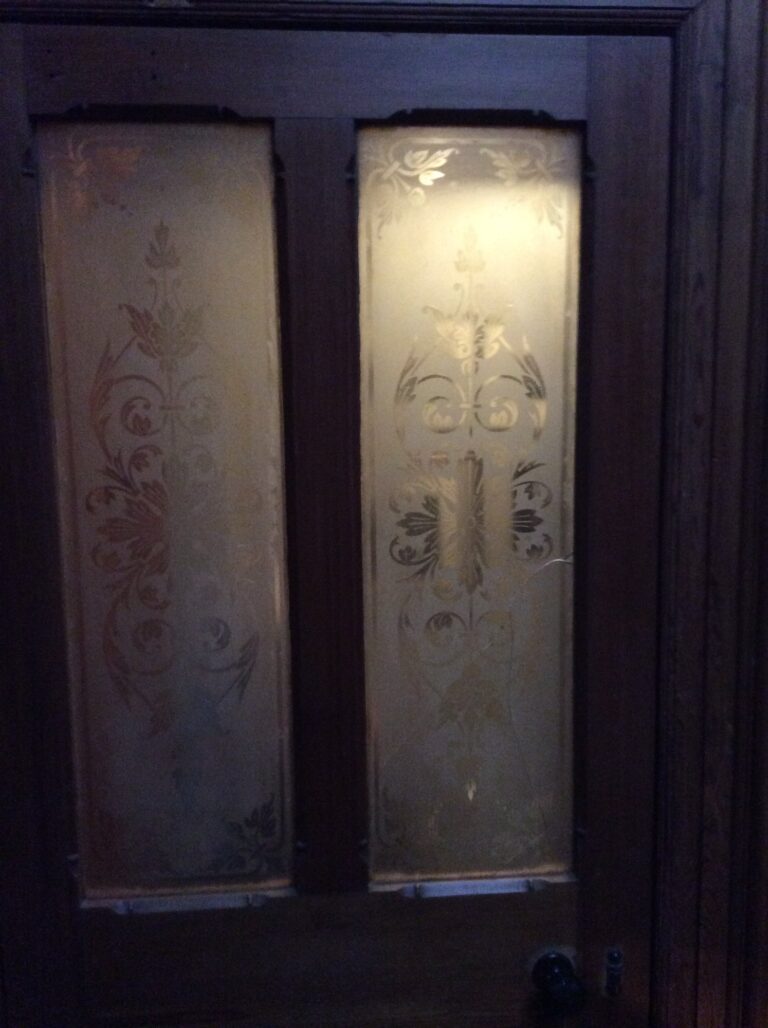 Pair of dark timber doors with etched glass panels