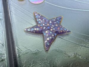 Purple glass star jewel flecked with coloured glass, set in textured relief glass