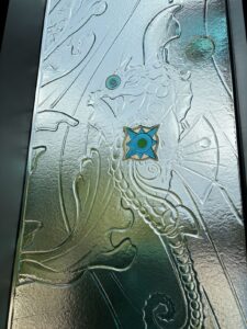 Textured relief glass panel with a seahorse shape and a blue jewel