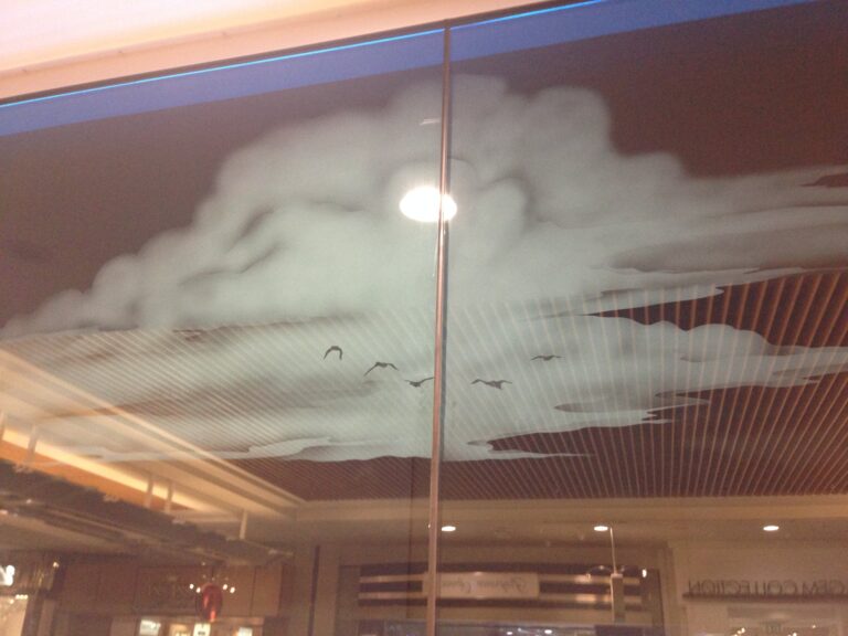 Sandblasted cloud and birds panel in a shopping arcade