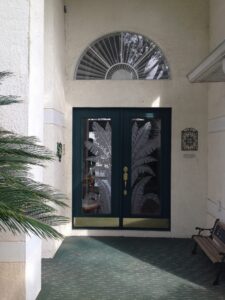 Palm leaf entrance doors with a sandblasted fanlight above