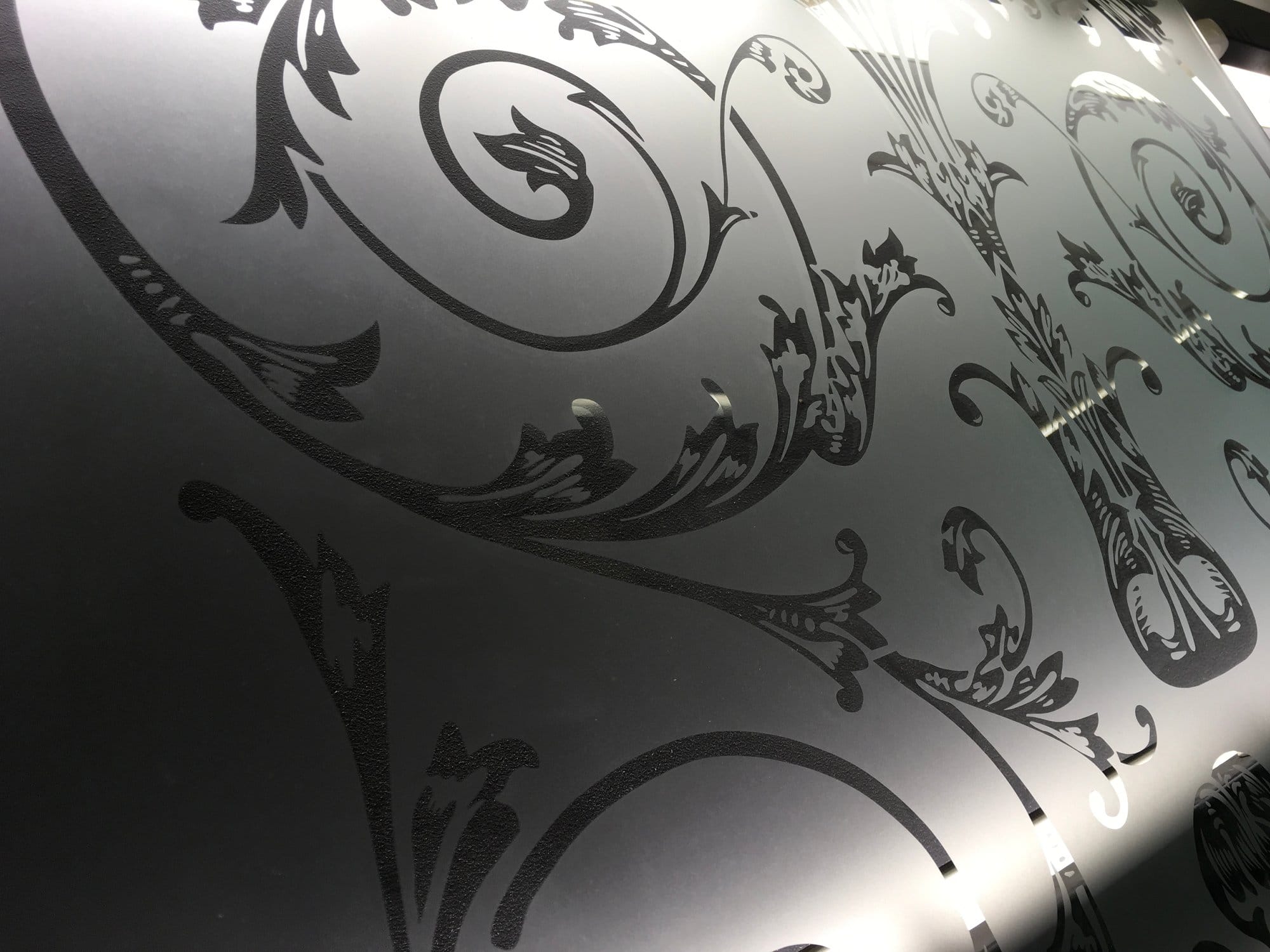 Close view of sandblasted scrollwork on glass