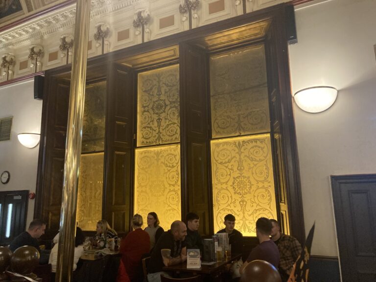 Tall etched windows with brass column in a pub