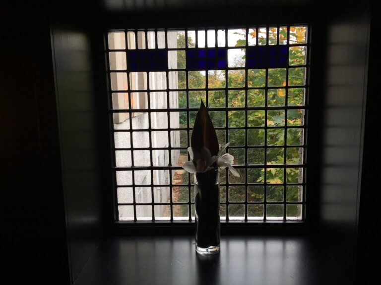 Tall leaded window with blue glass panes at the top