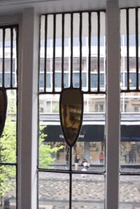 Tall leaded window with shield shaped glass and street view