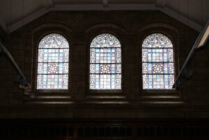 Three arched windows with patterned quarries wide