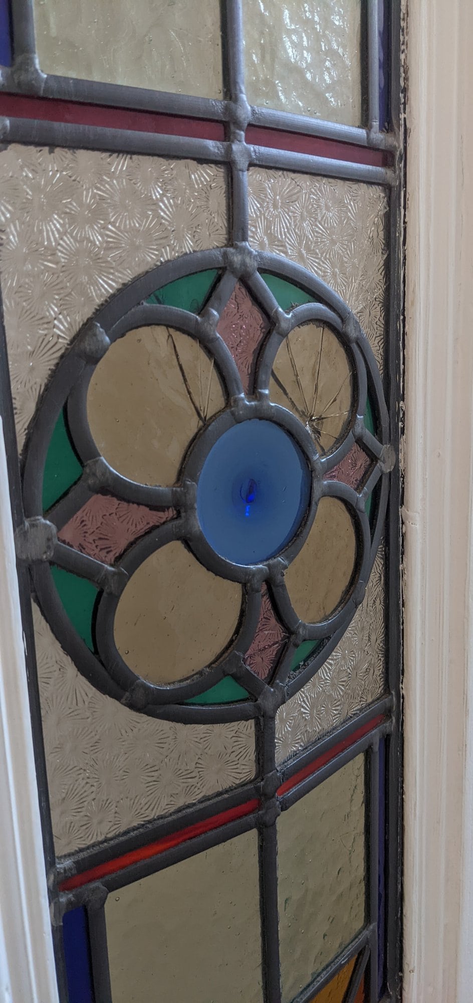Side view of a leaded door panel with bowing lead and a cracked roundel