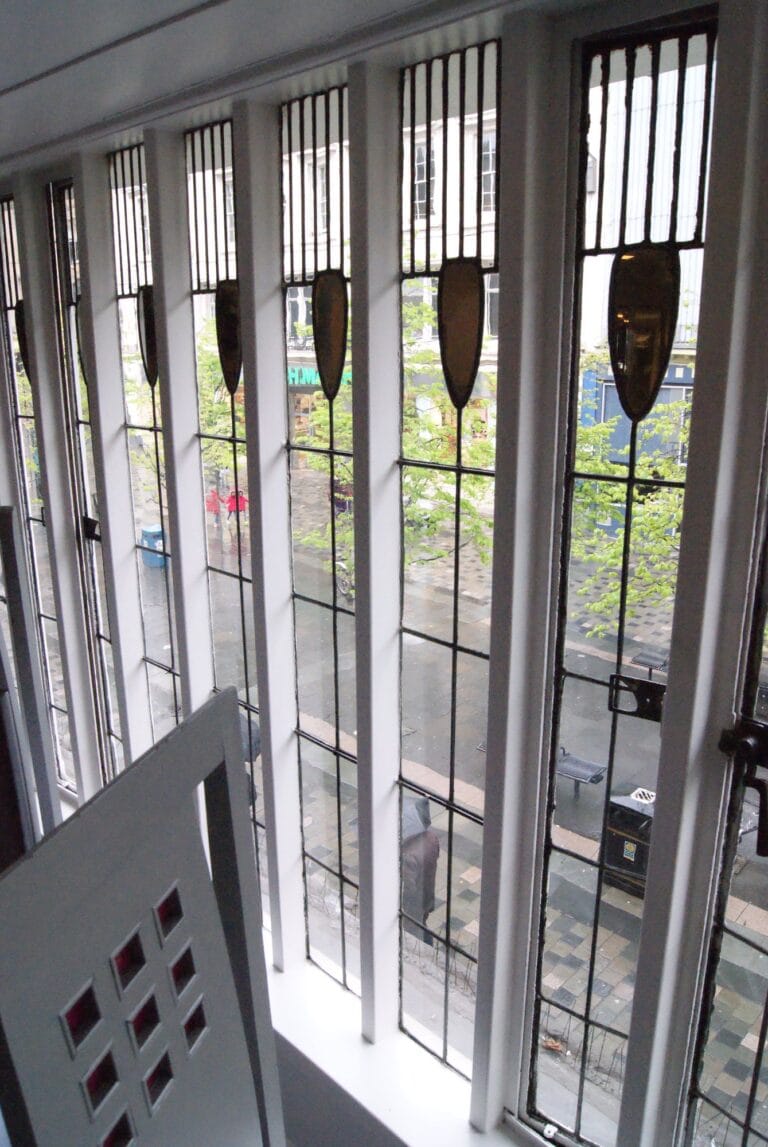 Leaded window in the Willow Tea Rooms with a pink glass chair back in the foreground, photographed in 2013