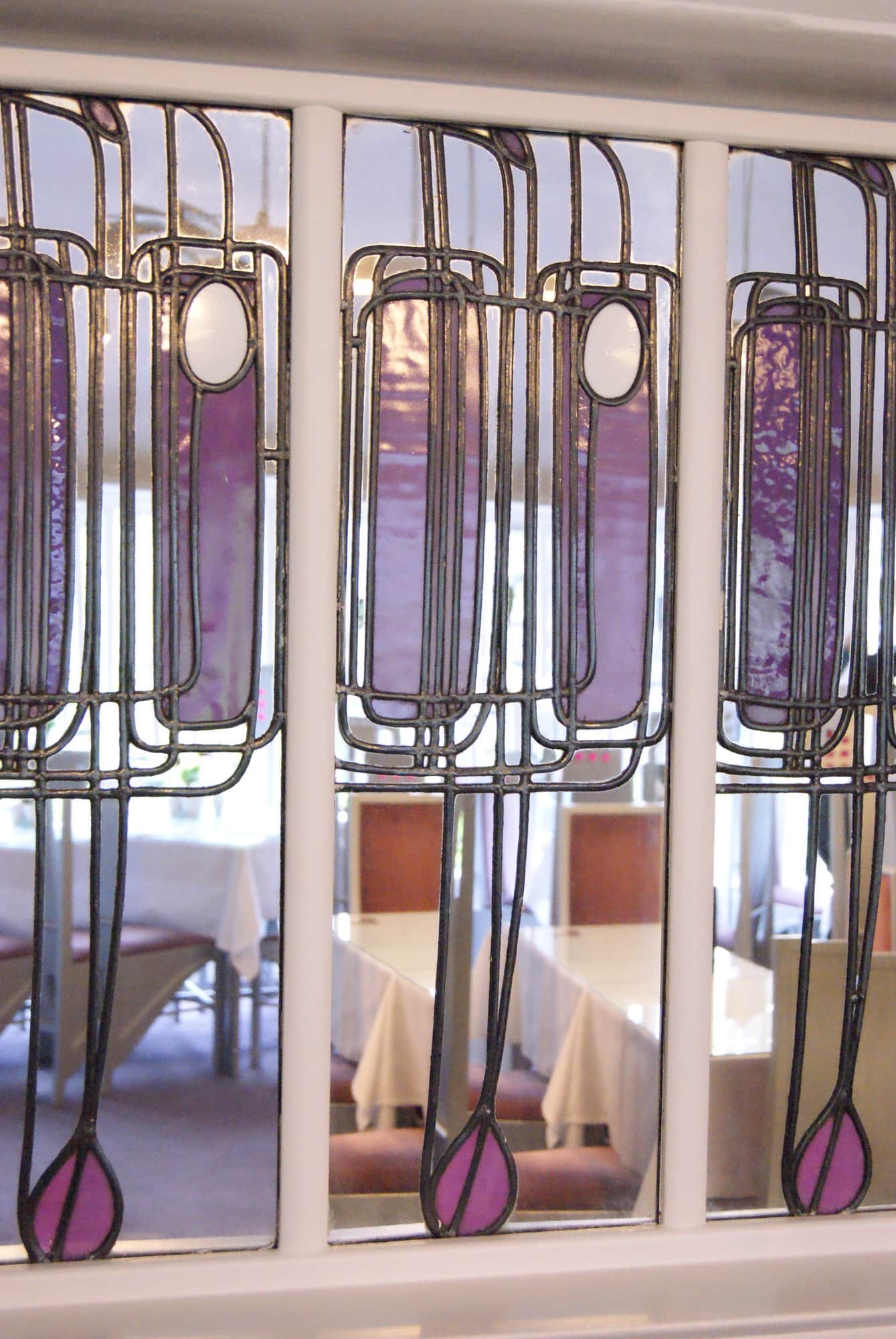 Tall purple leaded glass panels with long stems and rosebud shapes at the Willow Tea Rooms, photographed in 2013